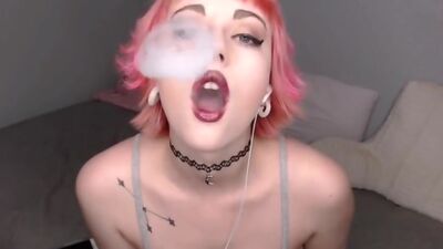 Hot emo punk girl with pink short hair smoking and teasting on webcam