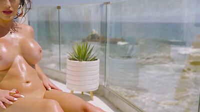 Barely clothed MILF CJ Sparxx reveals her massive boobs at her balcony