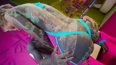 Tattooed dominatrix in pink Fishnet