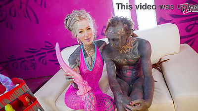 Tattooed dominatrix in pink Fishnet