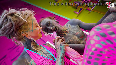 Tattooed dominatrix in pink Fishnet