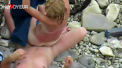 Beach Voyeur. Lucky guy getting his penis sucked while sunbathing on air mattress