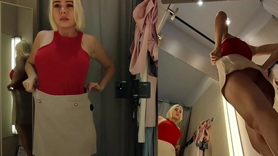 Blonde with big boobs tries on transparent clothes. Video from public dressing room