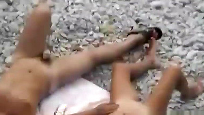 Black hair nudist and her man at beach